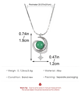 Detail view of crescent moon and star pendant with green bead and zircon insets