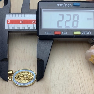 Close-up measurement of the gold Virgin Mary pendant height using a digital caliper