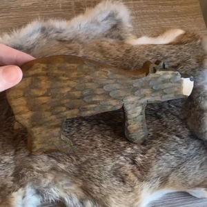 Close-up of hand-held brown bear wooden door stopper with detailed fur texture patterns