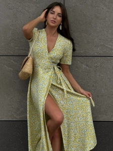 Detail of yellow floral wrap maxi dress with V-neckline, waist tie and high side slit