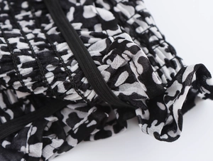 Dettaglio del tessuto in chiffon floreale con trama animalier ed elastico nero in vita