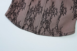 Détail de dentelle florale noire sur doublure en satin rose avec coutures de précision