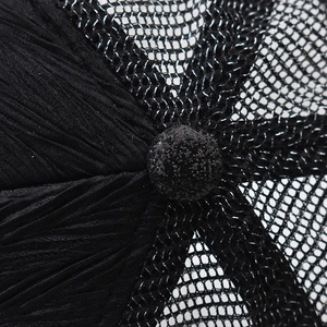 Macro shot of black sequin lace hat top showing pleated fabric and mesh texture detail