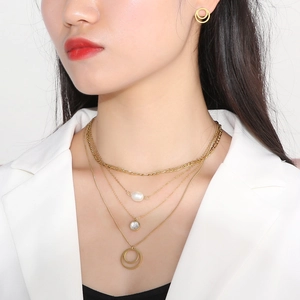 Detail of multi-layer gold necklace with pearl and zircon pendants with matching earrings
