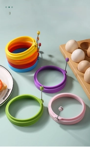 Close-up of colorful silicone egg molds with metal handles in seven vibrant colors