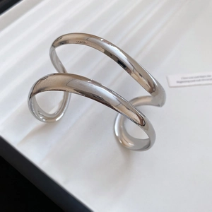 Detail of minimalist silver double-layer open cuff bracelet with polished mirror finish