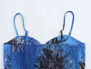 Detail view of floral print crop top with spaghetti straps and smocked back elastic design
