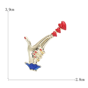 Creative enamel heart hand brooch in gold and red finish measuring 3.9cm by 2.8cm