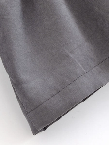 Detailed close-up of grey woven fabric texture and high-quality hem double stitching
