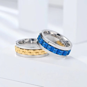 Macro shot of silver titanium fidget rings with gold and blue chain rotatable bands