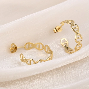 Macro detail of gold-plated titanium steel C-shaped earrings with hollow link design