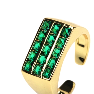 Macro shot of 18K gold ring featuring triple-row square emerald green zircons on white backdrop