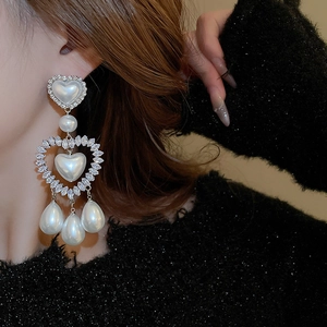 Dettaglio degli orecchini a cuore in argento con perle finte e cristalli brillanti