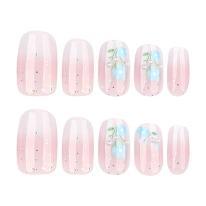 Pink gradient press-on nails with blue flowers, white pearls and glitter accents