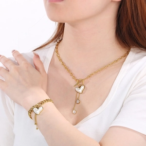 Detail von goldenem Titanstahl Herz Halskette und Armband Set an einem Model