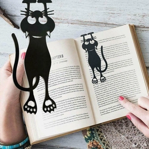3D cute black cat bookmark with expressive pose clipped onto an open book page
