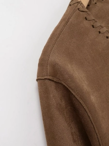 Détail de la veste en daim marron foncé montrant les coutures d'épaule et la texture