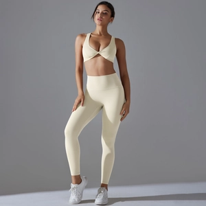 Detail of light cream yoga set with criss-cross sports bra and high-waist leggings