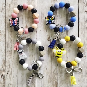 Detailed set of four colorful silicone bead keychains with tassels and animal charms