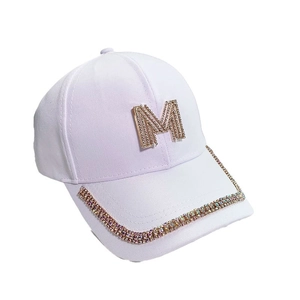 White cotton baseball cap with gold crystal M logo and colorful rhinestones on brim