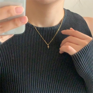 Minimalist 925 sterling silver gold star necklace worn on a black knit collar