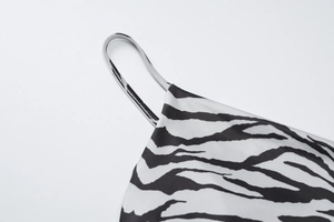 Close-up of zebra print fabric featuring thin straps and precise stitching details