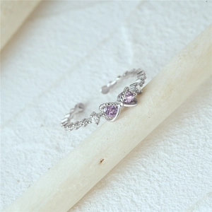 Macro detail of adjustable silver ring with purple heart stones and zircon accents