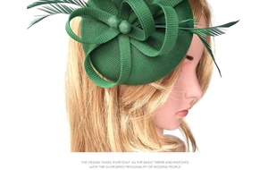 Detail of green mesh fascinator with feather accents displayed on a white model head