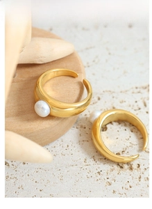 Detailed view of polished gold adjustable rings featuring elegant white freshwater pearls