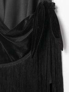 Detail view of premium black velvet fabric texture with long fringe tassels and knotted design