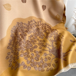 Detailed close-up of soft jacquard scarf showing tree leaf patterns and tassel edges