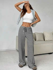 Detailed close-up of high-waisted black and white striped wide-leg trousers with drawstring