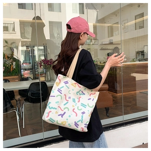 Action shot of large canvas tote bag with vibrant geometric patterns on a casual model