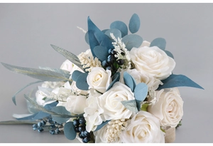 Detailed view of silk white roses with blue-green eucalyptus and navy berries in wedding bouquet
