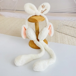 Detail showing plush rabbit earmuffs with moving ears and gold Love embroidery on white fur