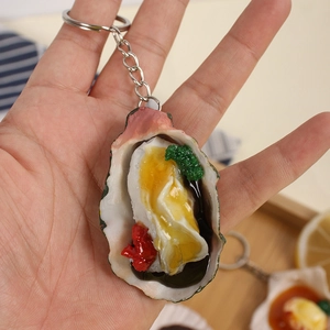 Realistic resin oyster keychain with chili and cilantro topping on a metal ring