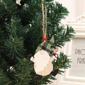 Detail eines hölzernen Wichtel-Anhängers mit Karomuster und Zuckerstange am Weihnachtsbaum