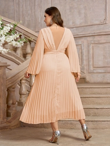 Dettaglio della trama a pieghe di un abito in chiffon a maniche lunghe con scollo a V