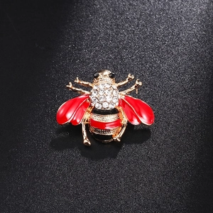 Golden honey bee brooch with red enamel wings and sparkling crystal rhinestones inlay