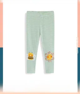 Detail of green striped leggings for girls with cute floral and bee embroidery patches
