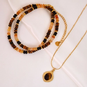 Tiger eye stone necklace and beaded bracelet set on white silk background