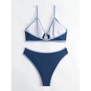 Detail view of navy blue ribbed bikini with metal ring and light purple trim details
