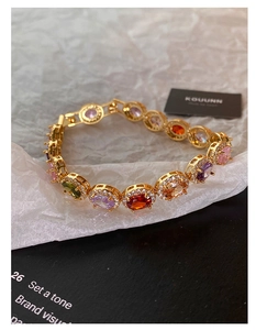 Macro shot of colorful oval gemstones with micro-inlaid zircons on a gold-plated bracelet