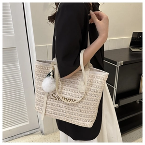 Detail of straw tote with Summer embroidery, white PU handle and pom-pom charm
