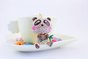 Detailed view of panda keychain with sparkling rhinestones and green enamel bamboo detail