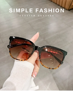Close-up of tortoise shell square sunglasses with brown gradient lenses and pearl chain