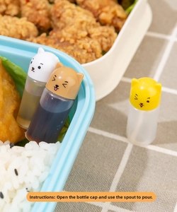Mini sauce bottles with cat and dog lids used in a bento box with fried chicken and rice