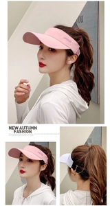 Detail view of pink and white sun visor hats with sports embroidery and adjustable strap