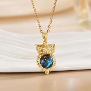 Elegant owl pendant necklace with blue cat eye stone on a delicate golden link chain