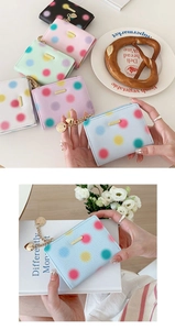 Detailed view of colorful polka dot zip wallet with heart pendant and Saffiano leather texture